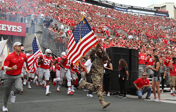 Sgt. John Siler, a member of the 174th Air Defense Artillery Brigade and a Purple Heart recipient, leads the Ohio State football team onto the field at Ohio Stadium.