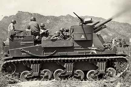 An M7 self propelled gun of Battery C, 987th Armored Field Artillery Battalion fires on a Communist target in Korea.
