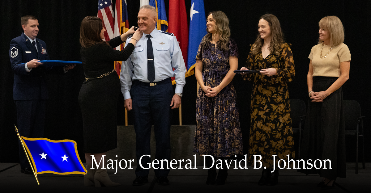 Gen. Johnson stands on stage with his family