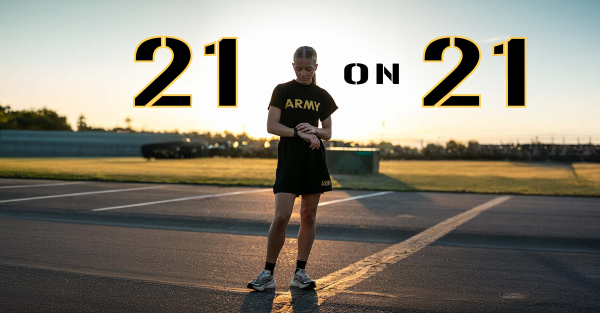 Female Soldier in Army shorts and t-shirt checking watch in parking lot.
