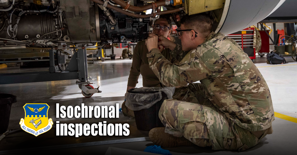 Airmen work on underside of aircraft