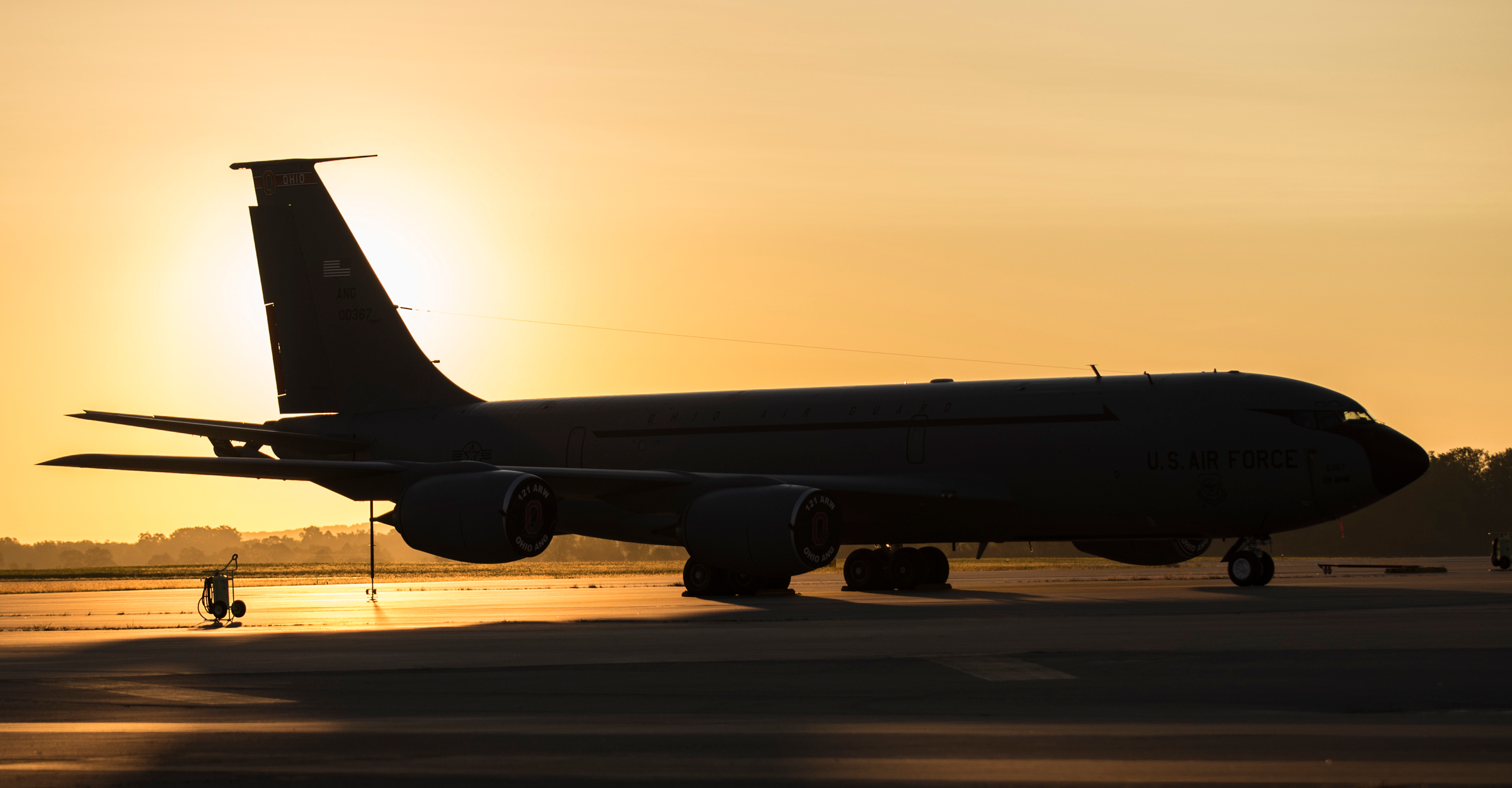 A KC-135 sitting on a flight line at sunrise