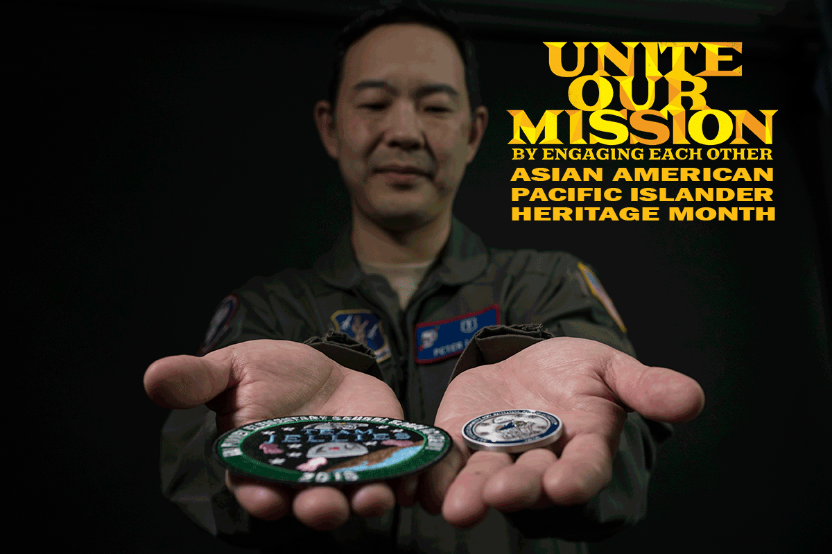 Airman in jumpsuit holds patch and coin. Headline reads: UNITE OUR MISSION BY ENGANGING EACH OTHER- ASIAN AMERICAN PACIFIC ISLANDER HERITAGE MONTH