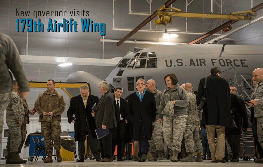 Ohio governor Mike DeWine with airmen in from 179th Airlift Wing in front of aircraft in hangar. 
