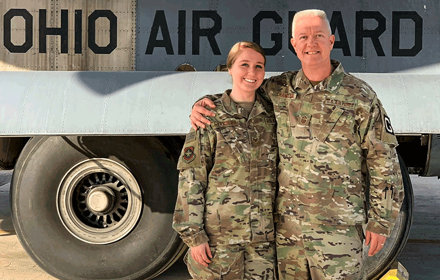 Father and daughter stand in camo in front of OHIO AIR GUARD aircraft.