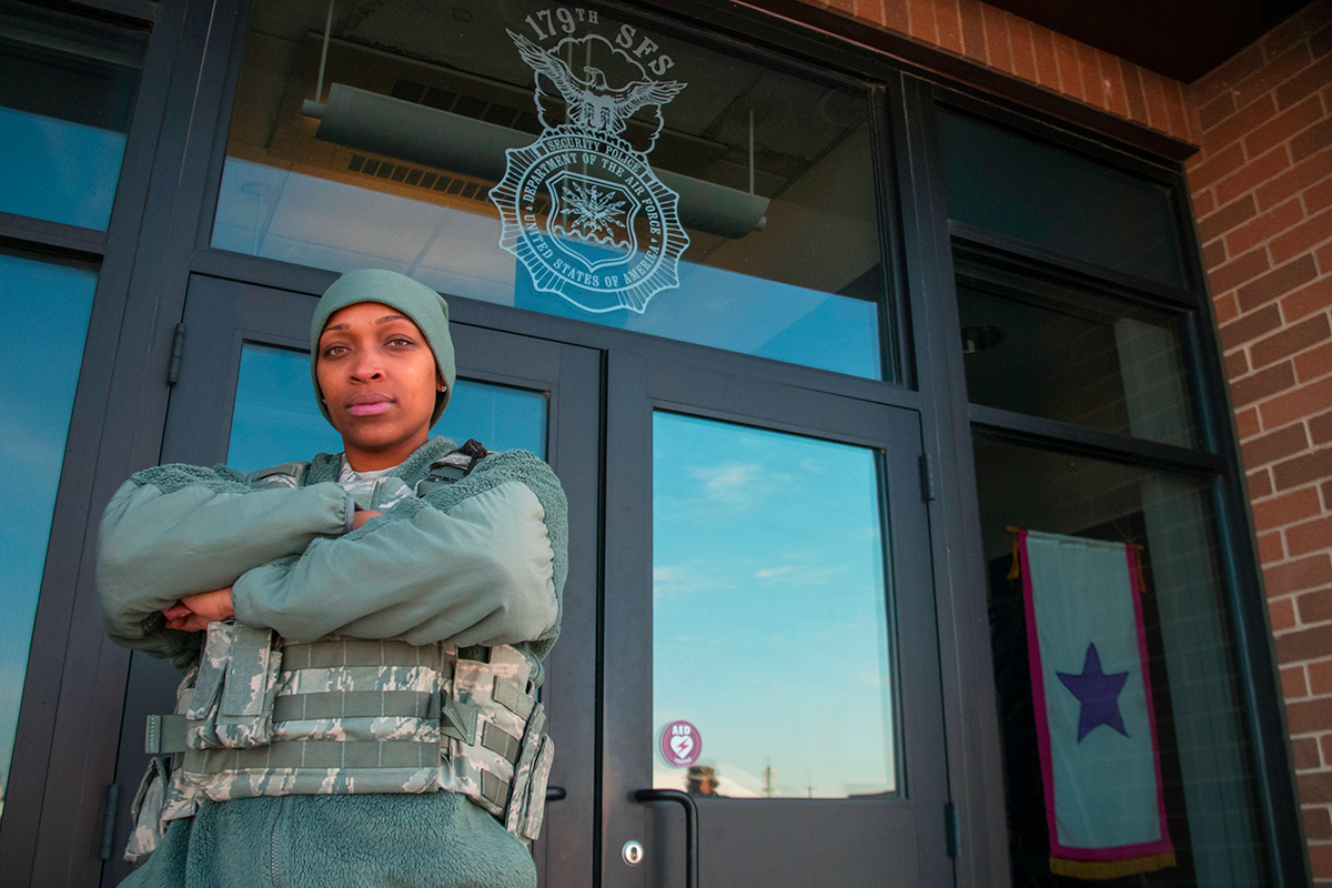 Senior Airman Dionna Sims stands in front of door to 179th building.