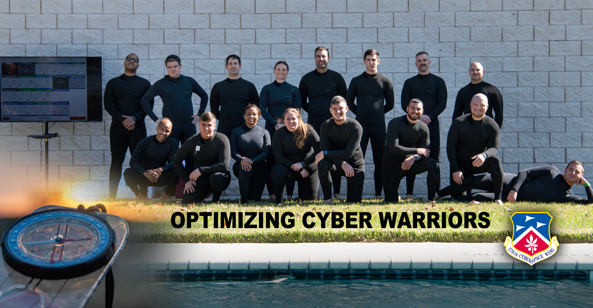 Airmen wearing wetsuits pose for a group photo behind a pool