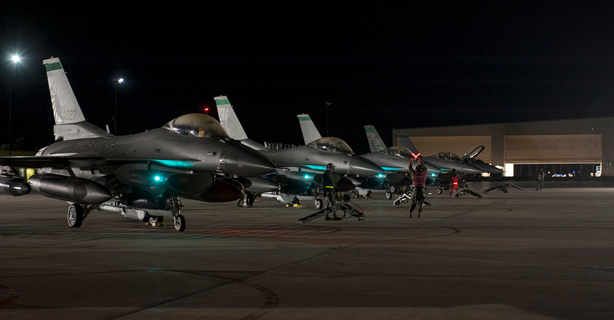F-16s on tarmak in dark of morning.
