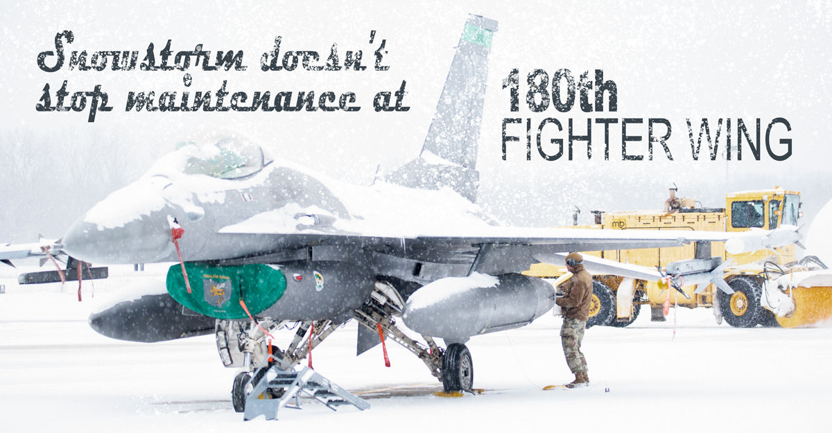 Guard member inspects F16 on tarmac in snow. 