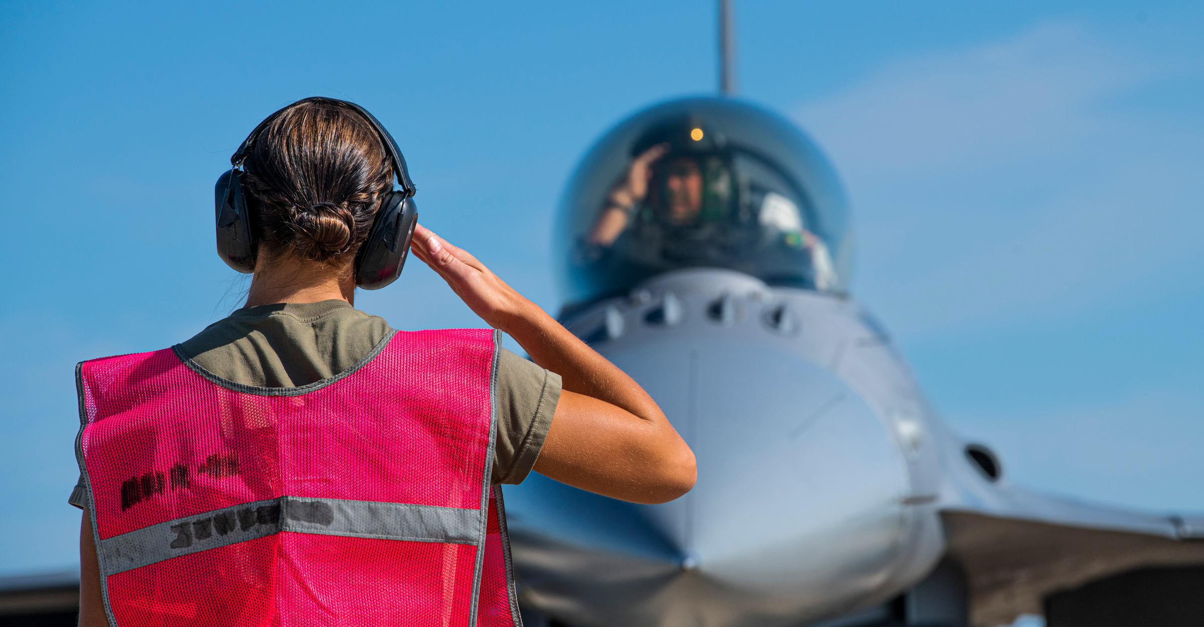 A weapons loader salutes an F-16 Fighting Falcon pilot