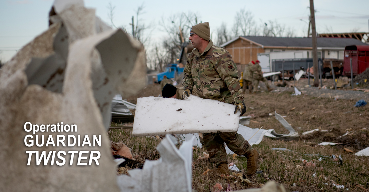 Airman gathers debris from torado.