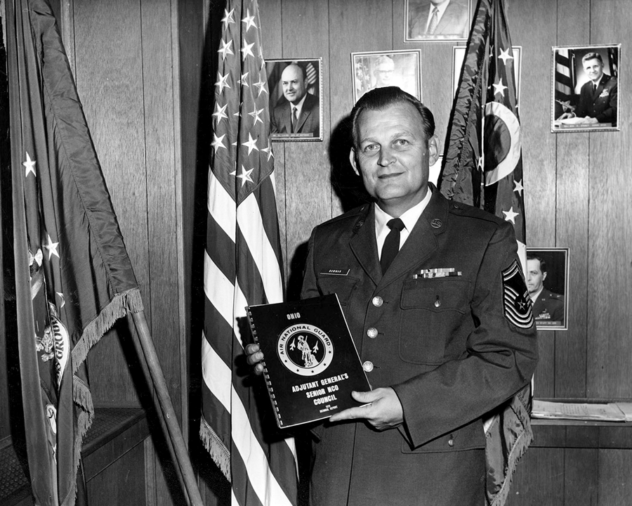 Black and white photo of CMS holding book.