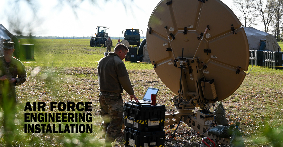 Airman stands with communications satellite