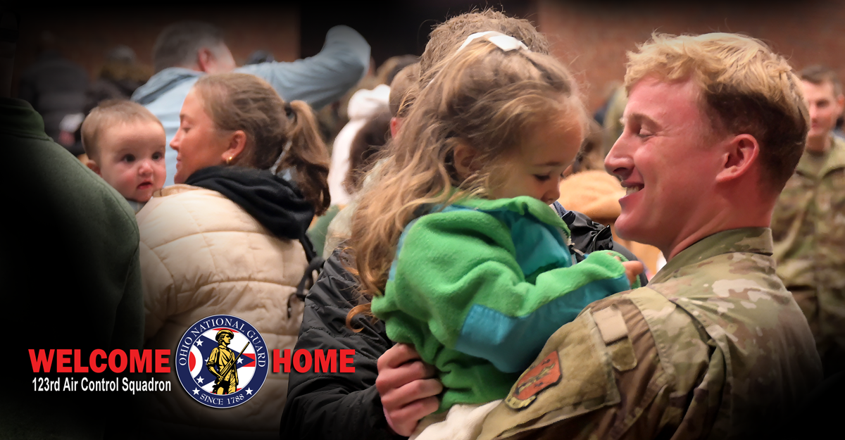 Airman smiling holding a child
