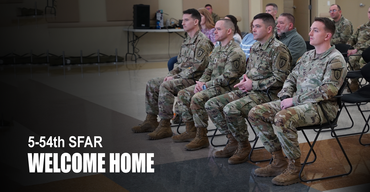 Soldiers sit in chairs in row