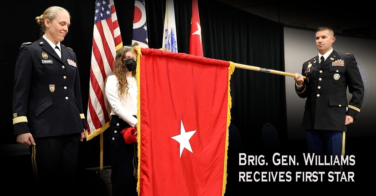 Buckeye Guard cover: BG Williams on stage with family as red one-star flag is unfurled.