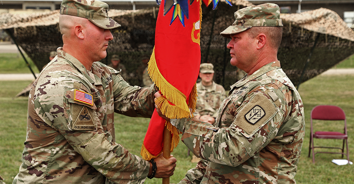 Lt. Col. Charles C. Springer  passes the battalion’s colors to Col. Thomas E. Moore II.