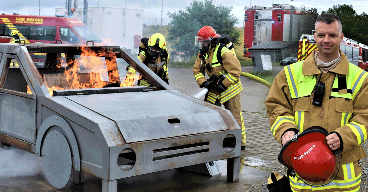 Firefighters putting out fire of simulated car with super-imposed image of Wysong.
