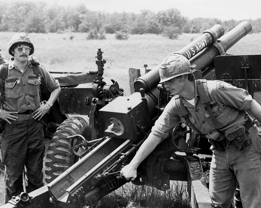Black an white photo of Soldiers loading missle launcher..