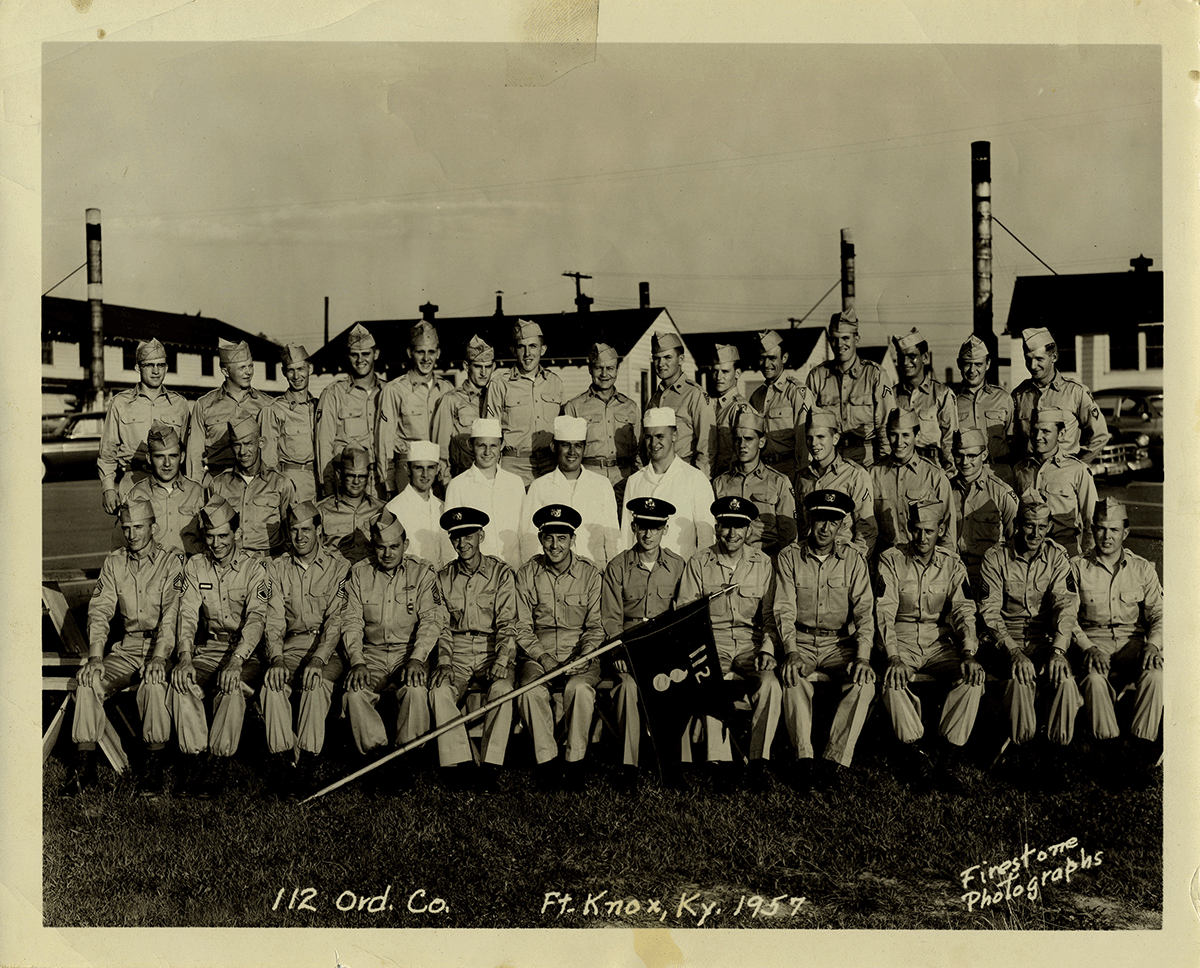 Sepia-tone photo from 1957 of Soldiers in rows fro group photo.