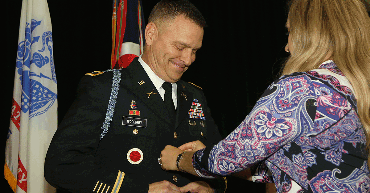 Col. Matthew S. Woodruff buttons his Army Service Uniform coat with the help of his fiancée.