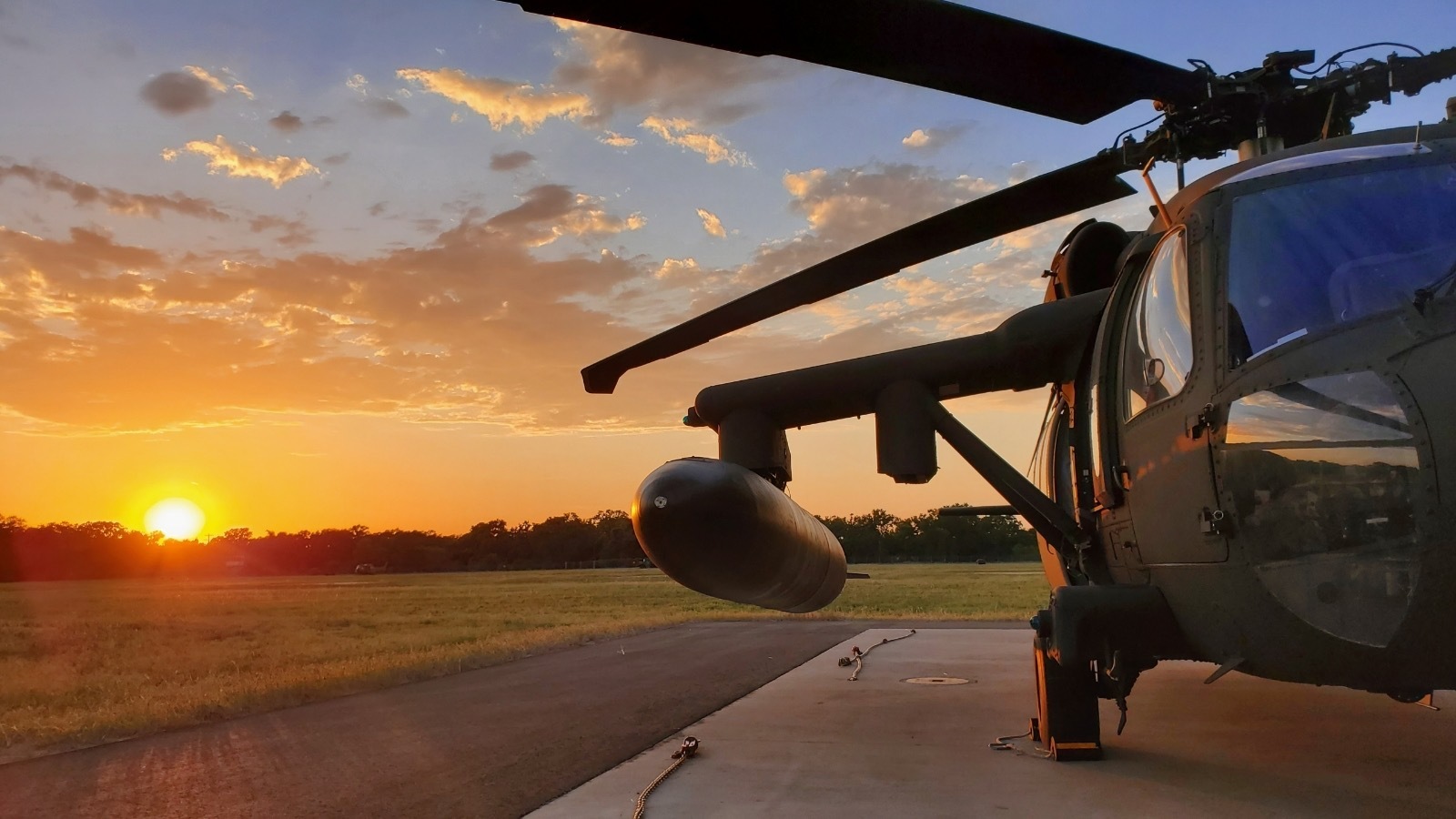 UH-60 Blackhawk on landing pad at sunrise.