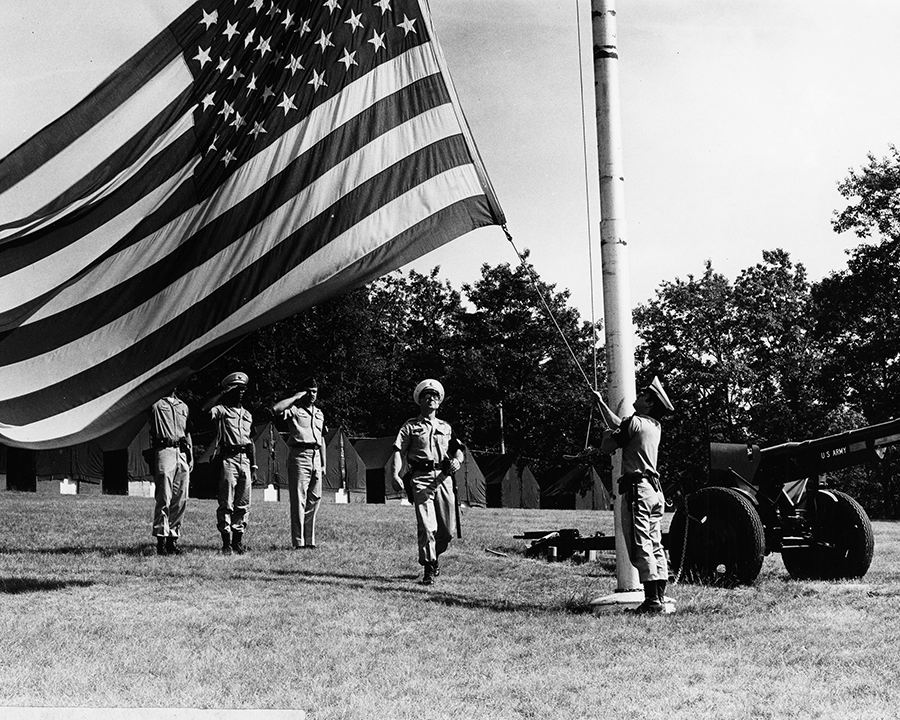 Soldiers raise American flag.