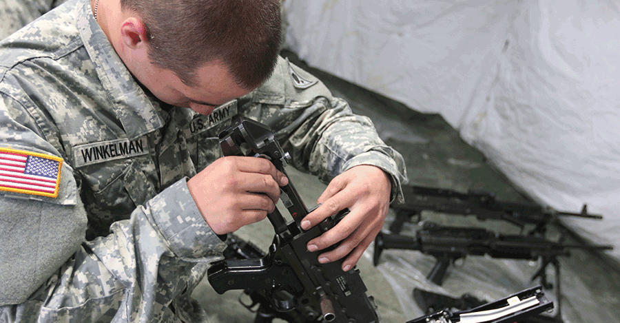 Soldier cleans weapon.