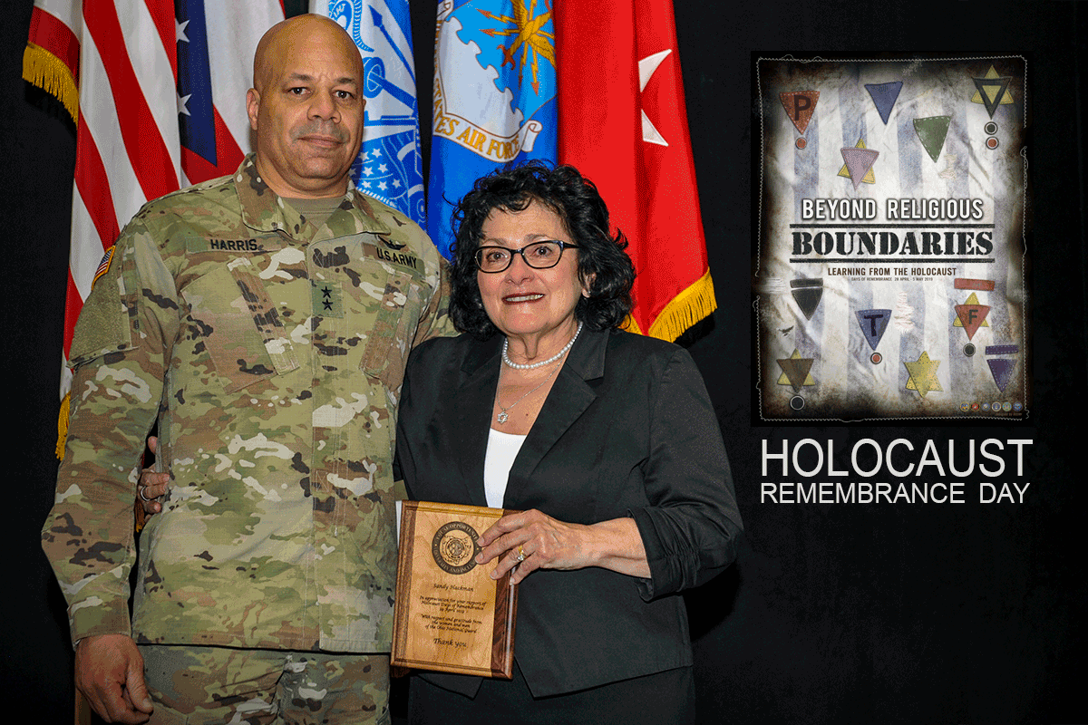 Maj. Gen. John C. Harris Jr., presents a plaque to Sandy Hackman.