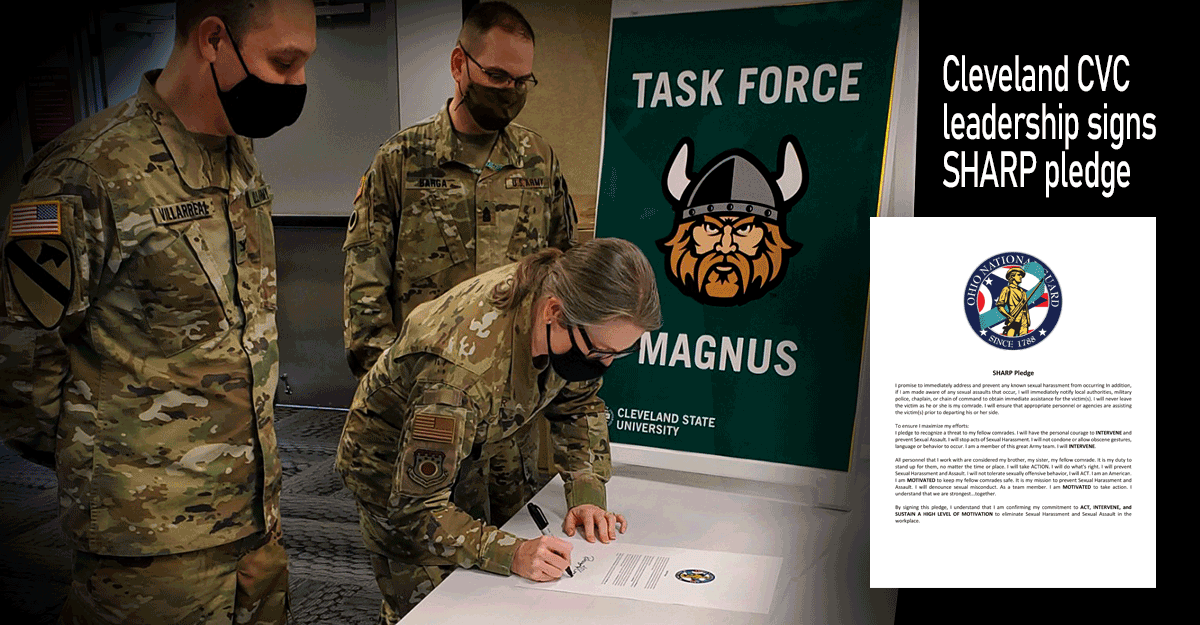 Brig. Gen. Rebecca O’Connor signs the SHARP pledge at table as commanders stand by.