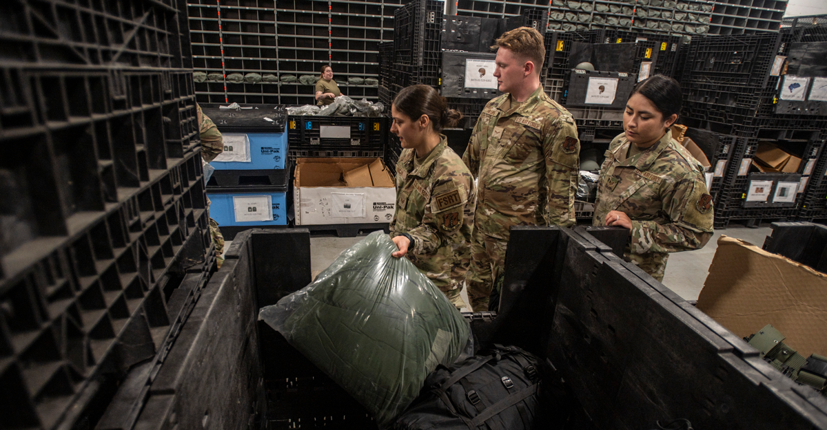 Airmen pulling supplies from supply room.