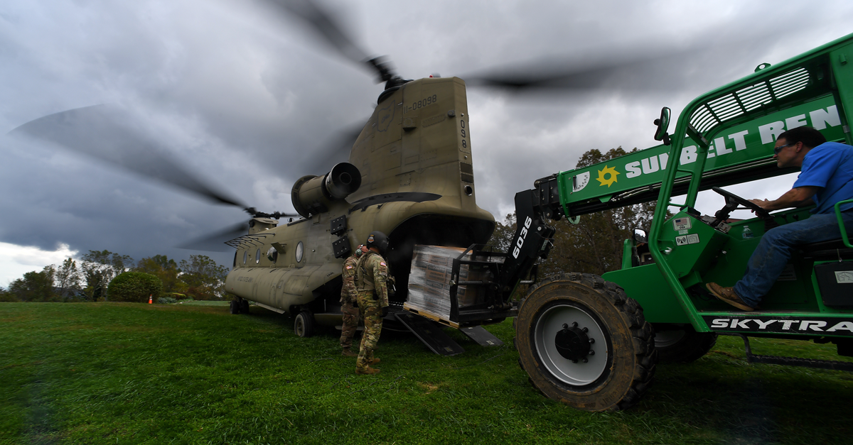 Airman load a CH-47 Chinook helicopter.