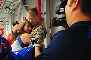 SSgt. Brandon Cole, an F16 aircraft mechanic, embraces his girlfriend during an interview with a local television station, 13abc, after returning home from deployment. 