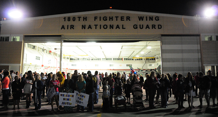 Family of deployed Airmen wait on the flight line for their loved ones to land at the 180th Fighter Wing.