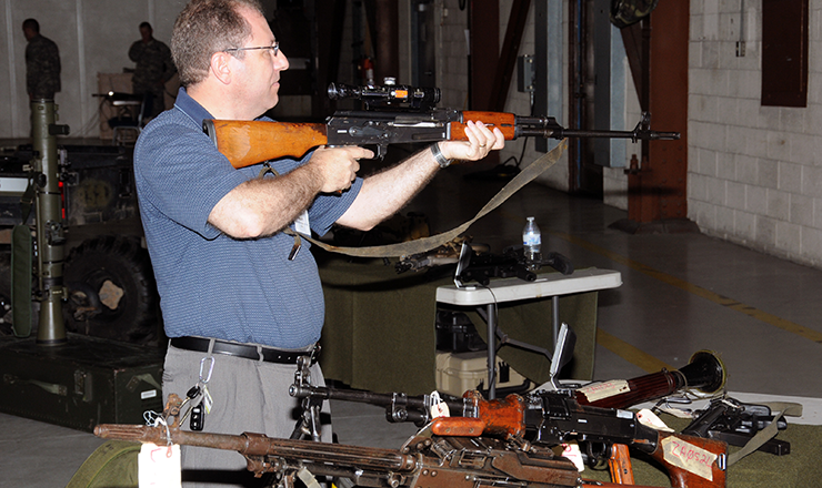 Pastor Dan Alexoff, of the First Freedom Baptist Church in Brimfield, Ohio, inspects an AK series assault rifle, part of a Special Forces weapons display.