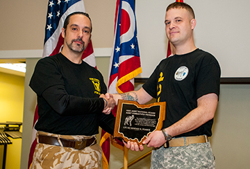 Staff Sgt. Kyle J. Walter (right) presents retired Lt. Col. Howard Pearce an award of recognition for being the guest of honor at the second annual Ohio Army National Guard Combatives Tournament.