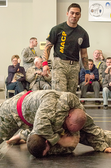 Staff Sgt. Roger Richie (standing) of the 437th Military Police Battalion referees a match.