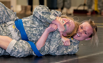 Cadet Valerie Stearns (right) of the 323rd Military Police Company tightens her chokehold on Spc. Madeline E. Herman of the 135th Military Police Company.
