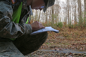 Spc. Chelsea Bond, a chemical, biological, radiological and nuclear specialist with the 637th Chemical Company in Kettering, Ohio, checks points on her map during a land navigation course.