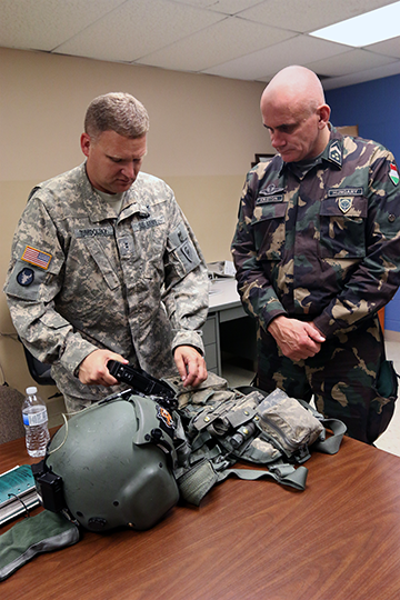 Chief Warrant Officer 2 Paul Tumidolsky (left), an aircraft maintenance officer with Company A, 1st Battalion, 137th Aviation Regiment, goes over his flight equipment with Command Sgt. Maj. István Kriston, command sergeant major of the Hungarian Defence Forces, Sept. 21, 2015, at Rickenbacker Air National Guard Base in Columbus, Ohio. 