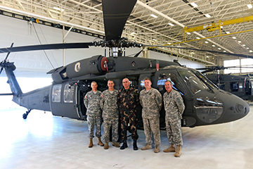 Command Sgt. Maj. István Kriston, command sergeant major of the Hungarian Defence Forces, stands with members of the Ohio Army National Guard in front of a UH-60 Black Hawk helicopter.