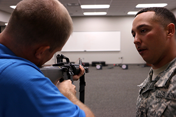 An Ohio Army National Guard staff sergeant instructs an employer how to use an M16A2 rifle.