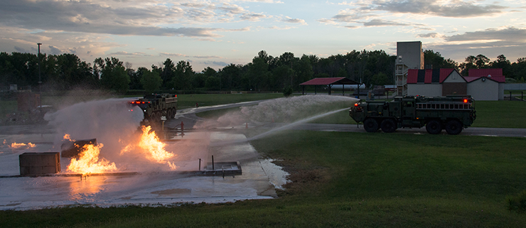 Ohio Army National Guard firefighters with the 295th and 296th Engineer Detachments train with the 513th Engineer Detachment in a live burn exercise in early morning light.