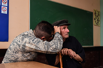 An Ohio Air National Guard physician checks the ears of a Serbian man.