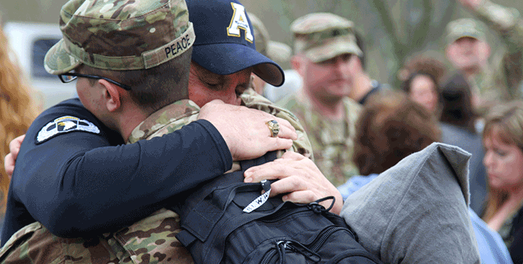 A Soldier gets one last hug before loading a bus after the unit’s call to duty ceremony.