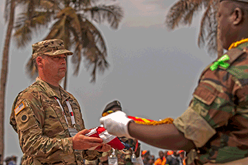 U.S. Army Col. Kevin Edwards, an Ohio National Guard nurse practitioner, accepts the U.S. Flag during of the exchanging of flags at the VIP Day closing ceremony.