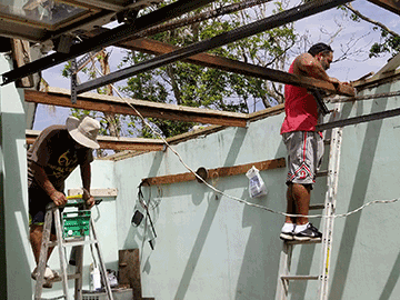 Retired Ohio Army National Guard Master Sgt. Eddie Berio Jr. (right) and his uncle Louis make repairs to the garage of his grandfather’s home in Arecibo, Puerto Rico.