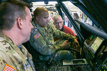 Chief Warrant Officer 4 Robert Diamond (left), an instructor pilot with Headquarters and Headquarters Company, 1st Battalion, 137th Aviation Regiment, guides Maj. Gen. John C. Harris Jr., Ohio assistant adjutant general for Army, through the new navigation system on a UH-60M Black Hawk helicopter.