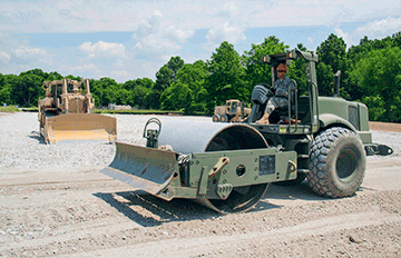 Spc. David Wilson, a heavy construction equipment operator with the 1191st Engineer Company, operates a roller compactor at a parking lot construction site for the Unit Training Equipment Site (UTES) facility at Camp Ravenna Joint Military Training Center.