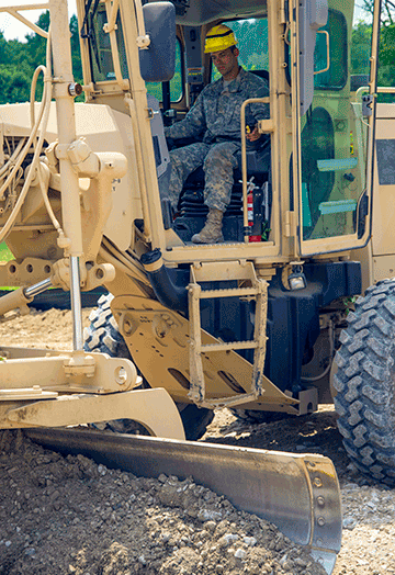 Second Lt. Christopher Dorson-King, 1191st Engineer Company executive officer, operates a motorized road grader at a parking lot construction site.